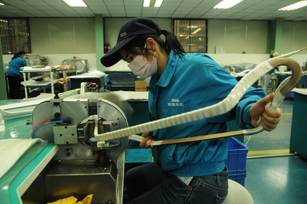 威能公司(sī)線圈車間高壓線圈組正在進行成型線圈的機包作業(yè) 威能公司線圈車間高壓線圈組正在進行成型線圈的(de)機包作業